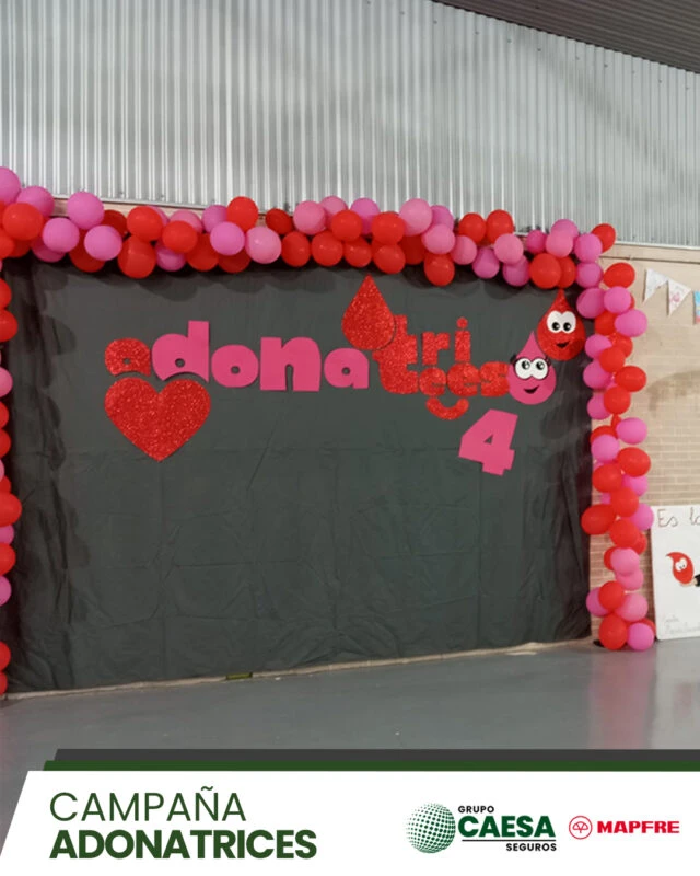 Arco rojo de globos con el lema 'adonatrices' en la jornada de donación