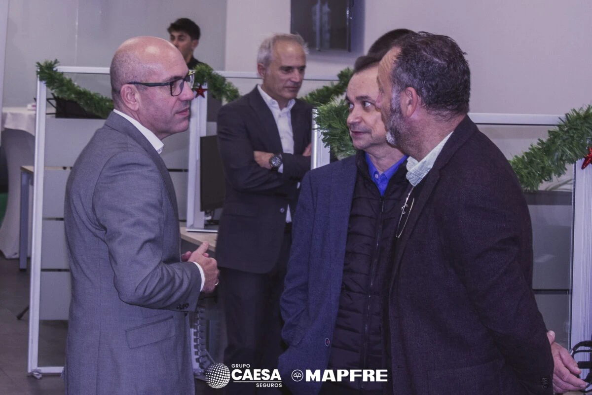 Tres invitados conversando en el evento de apertura de la nueva oficina