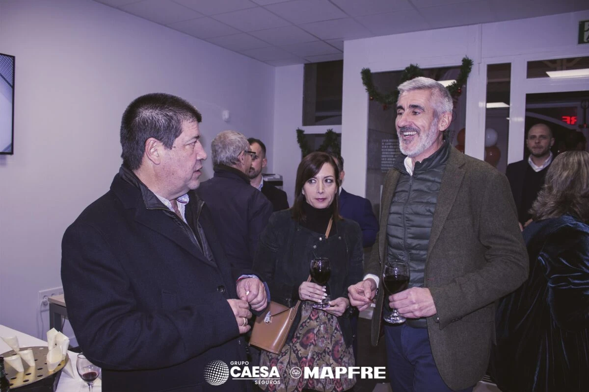 Asistentes brindando con copas durante el cóctel de la nueva oficina